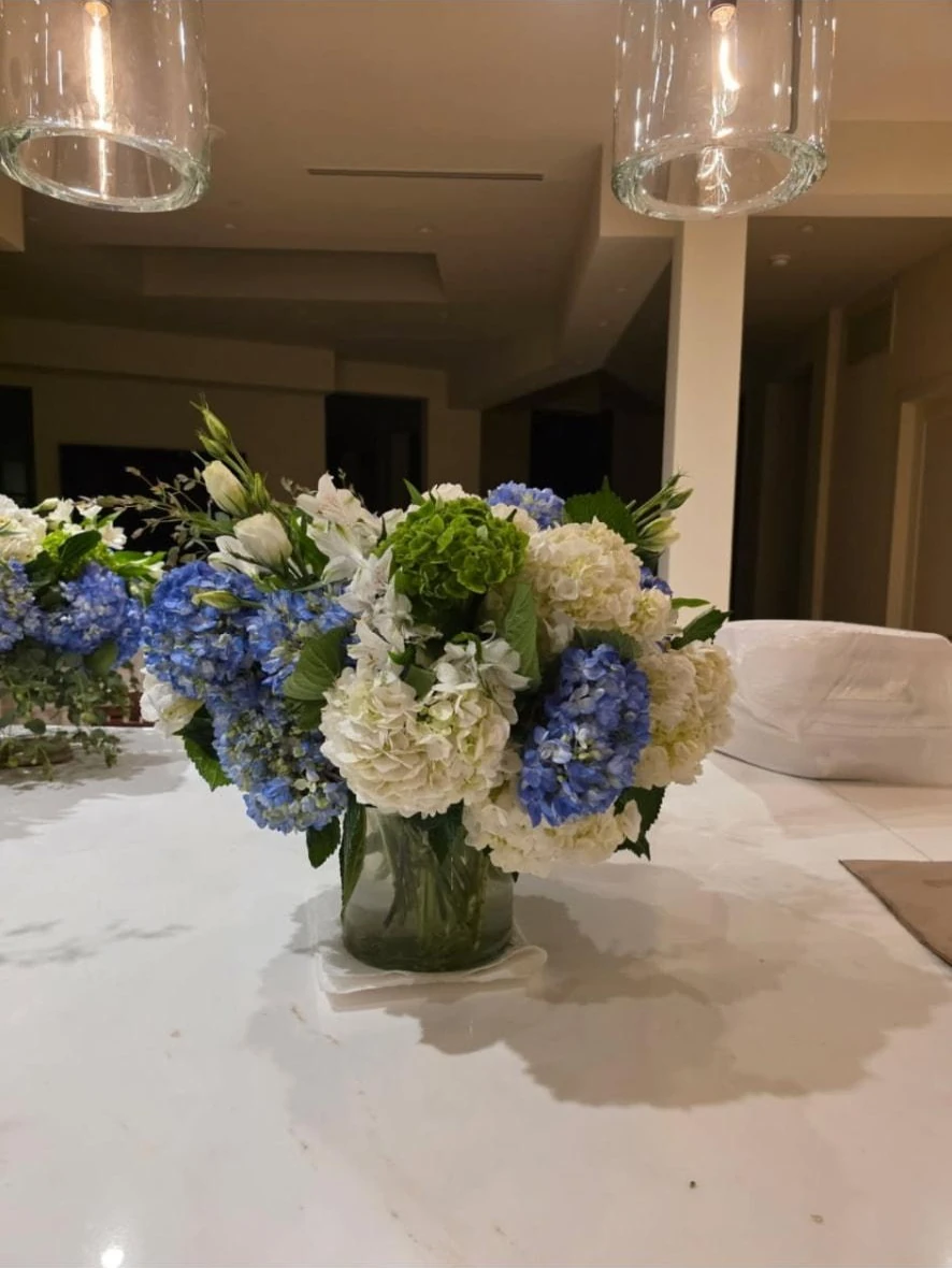 Floral Décor: Blue and white hydrangea arrangement with greenery in a glass vase on a marble counter