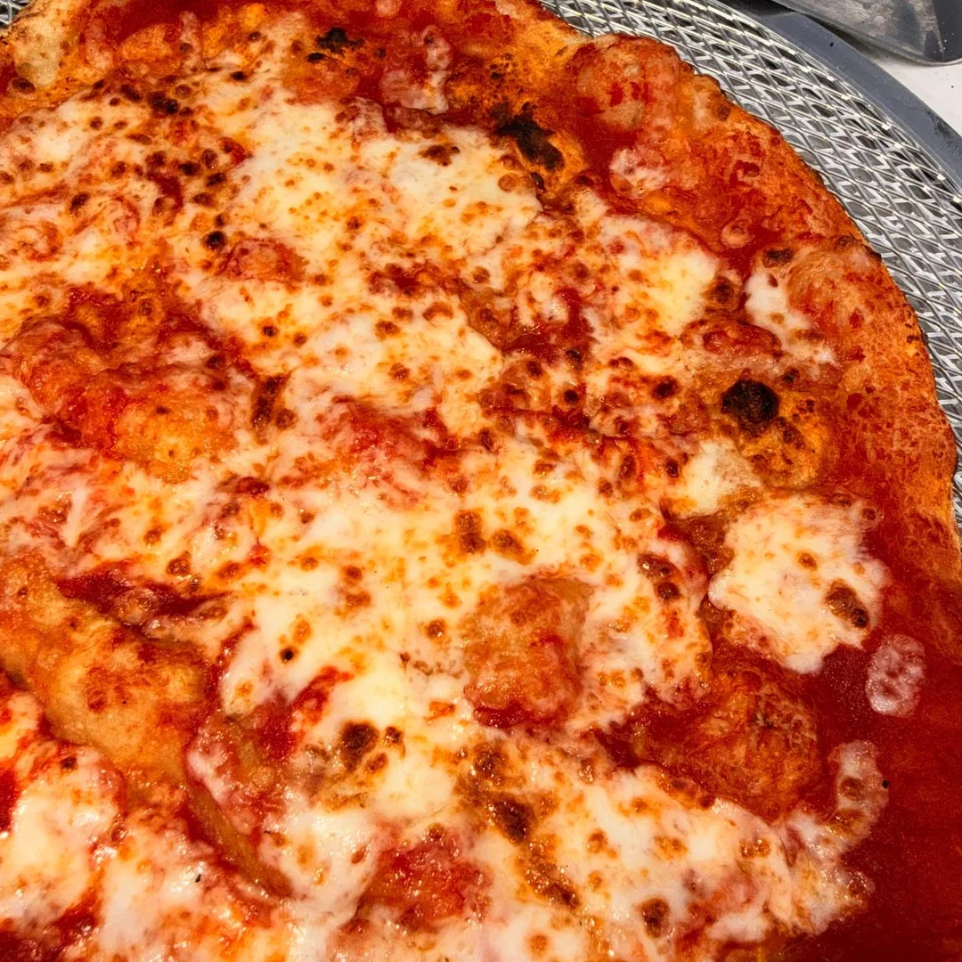 Close-up of melted mozzarella and golden Neapolitan pizza crust