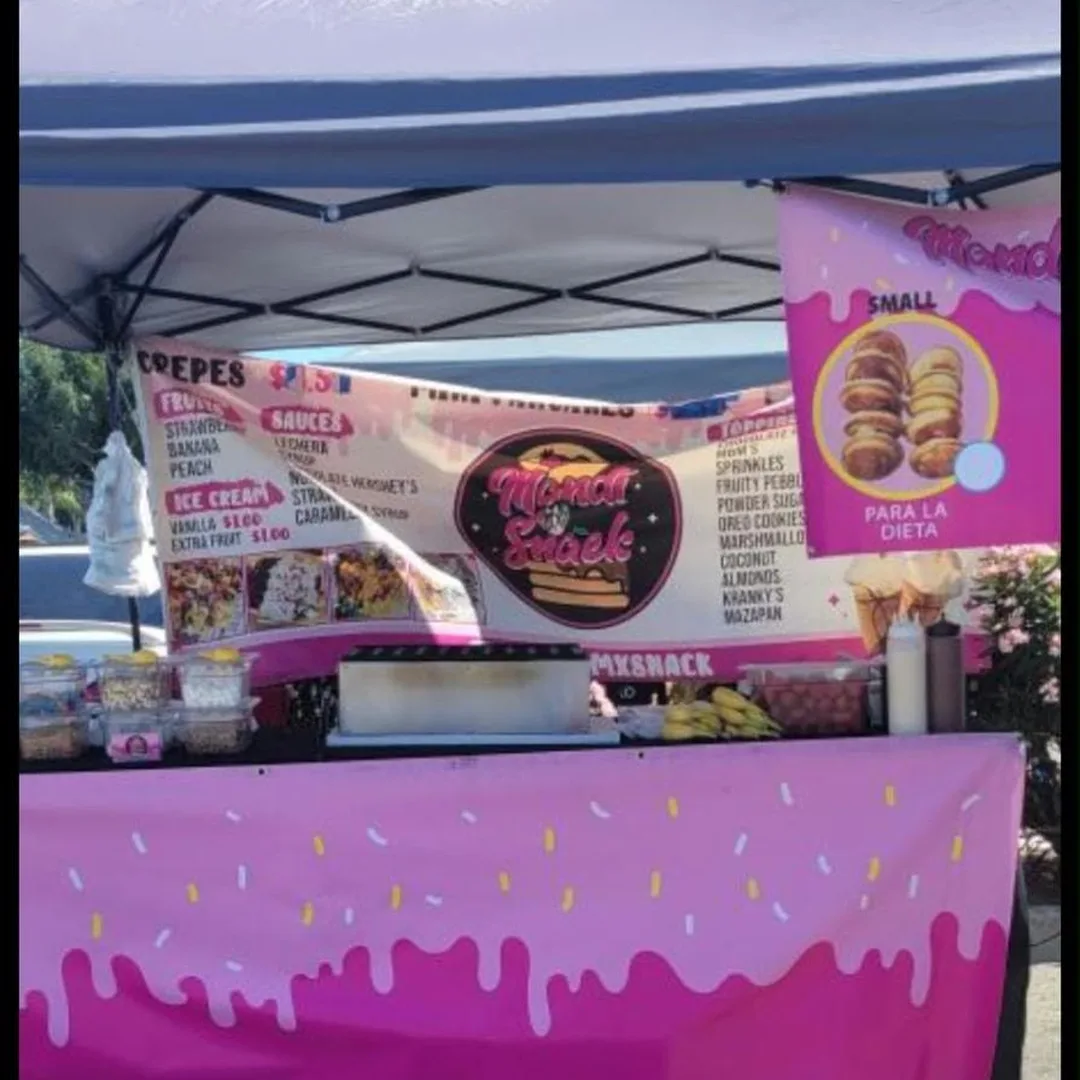 Pink dessert stand under a canopy with crepe and mini pancake menus