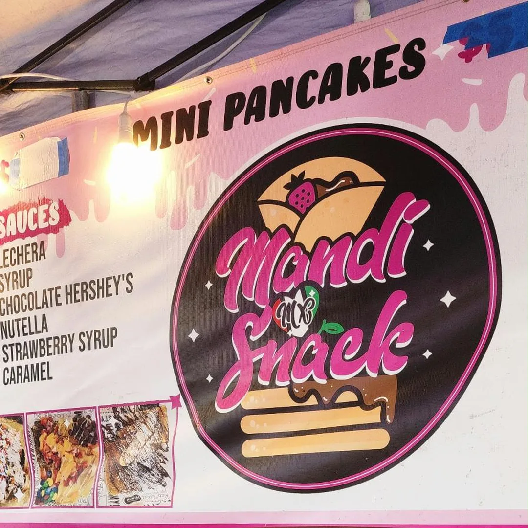 Mini pancake griddle in front of the sauces menu and stand sign
