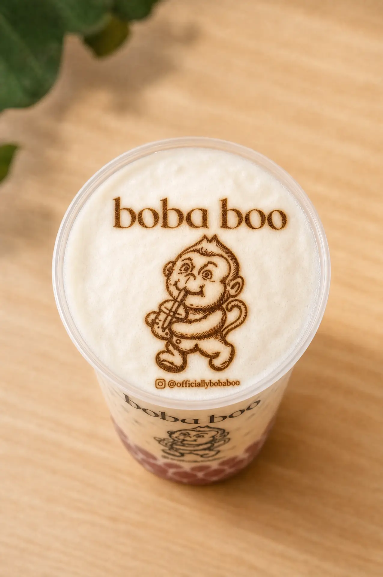 Milk tea with the boba boo monkey logo printed on the foam