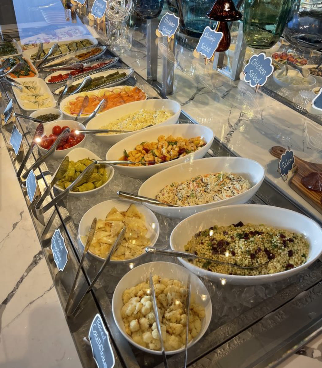 Chilled salad and appetizer buffet on ice with handwritten dish labels